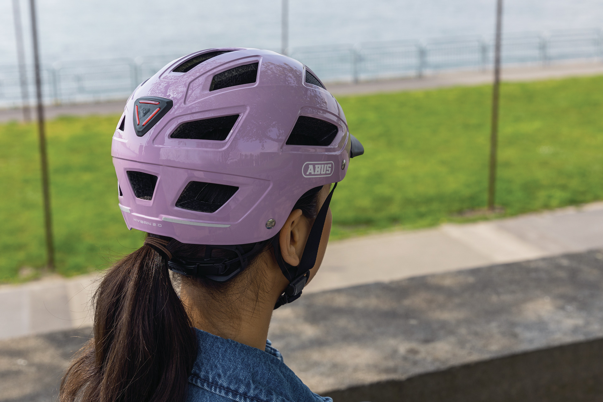 Casque ABUS Hyban 2.0 mauve porté, vue arrière du feu et des réflecteurs